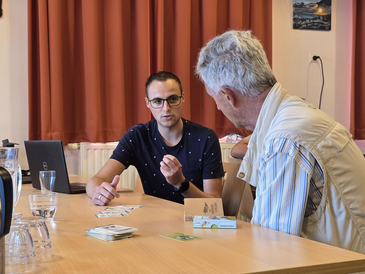 Een medewerker van de Provincie Zeeland is in gesprek met een geïnteresseerde inwoner tijdens het stikstofspreekuur in Vrouwenpolder