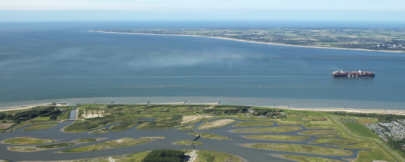 Een luchtfoto van de Westerschelde met op de voorgrond Waterdunen.