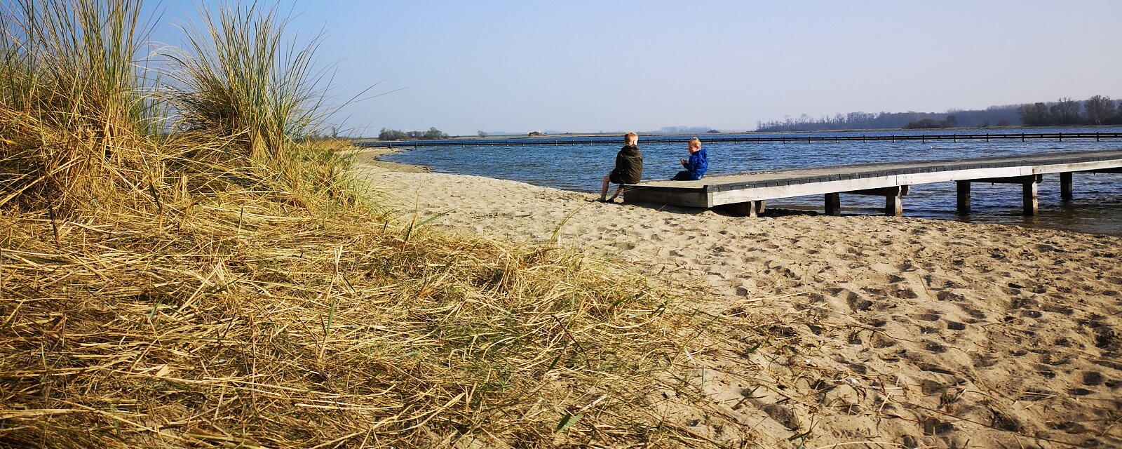 Dagrecreatie langs de oevers van het Veerse Meer. Twee kinderen op een steiger.