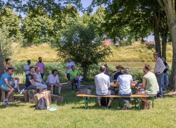 mensen houden rondetafelgesprek in stadspark Hulst