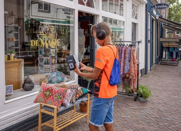 jongen met koptelefoon loopt door Middelburg