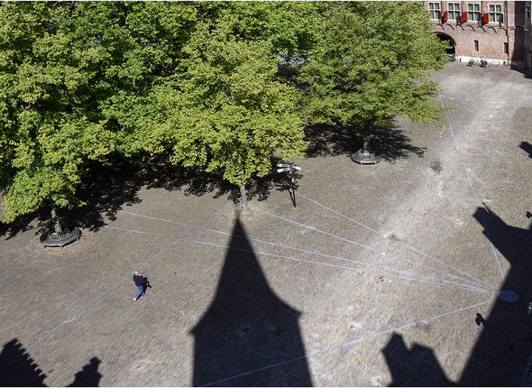 Luchtfoto van de Abdij in Middelburg met de schaduw van de gebouwen en een grote boom.