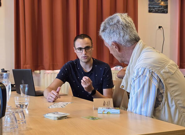 Een medewerker van de Provincie Zeeland is in gesprek met een geïnteresseerde inwoner tijdens het stikstofspreekuur in Vrouwenpolder