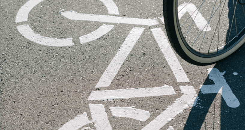 een gedeelte van een fietswiel in beeld en het asfalt van het fietspad