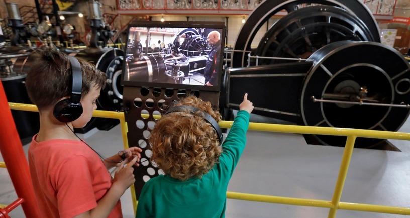 2 kinderen met koptelefoon kijken naar stoommachine. Beeld: Industrieel Museum Zeeland