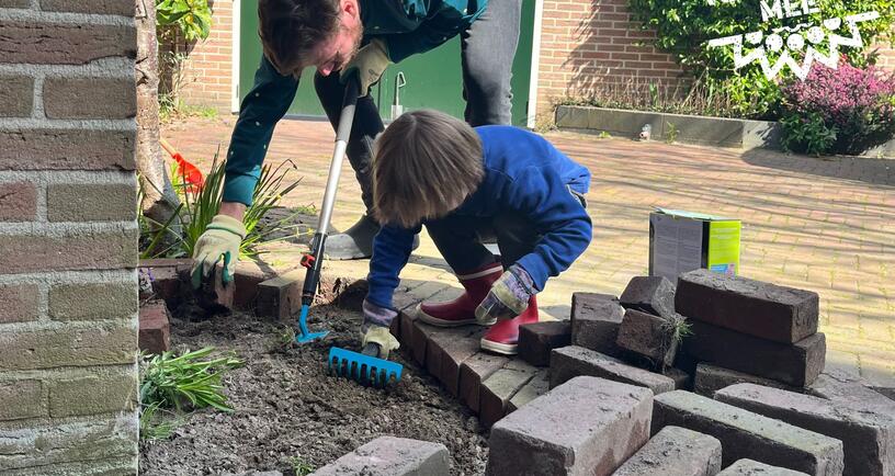 Man en kind wippen tegels uit tuin