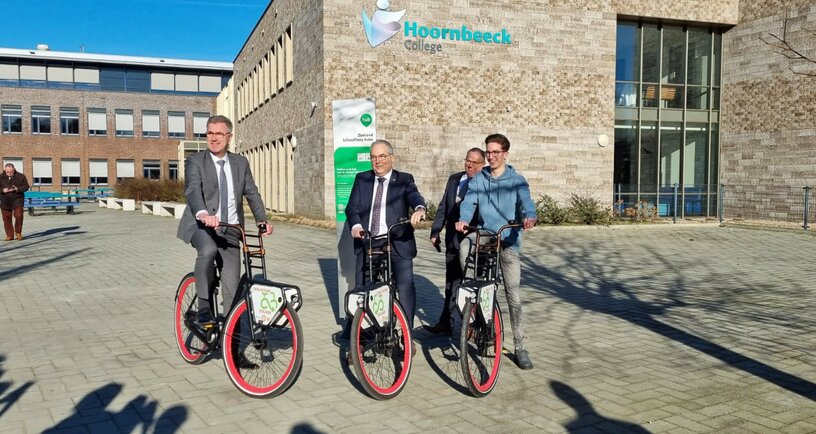 Gedeputeerde Harry van der Maas op de fiets bij het Hoornbeeck College in Goes
