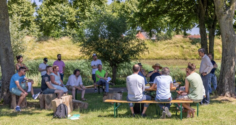 mensen houden rondetafelgesprek in stadspark Hulst