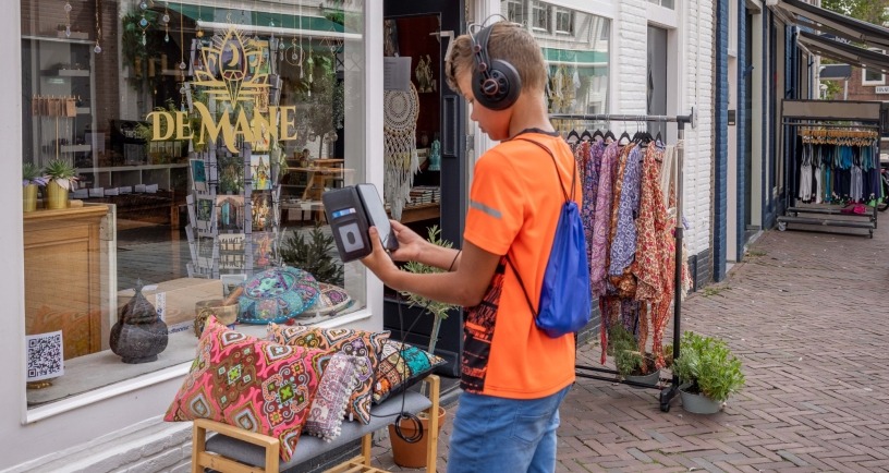 jongen met koptelefoon loopt door Middelburg