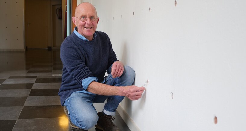 Hans Woittiez bij de gaten in de muur van het hoofdgebouw