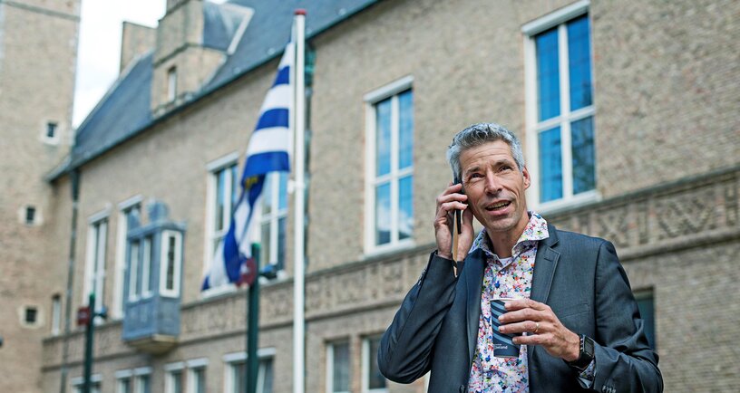 Persoon belt mobiel voor ingang Provinciehuis Middelburg