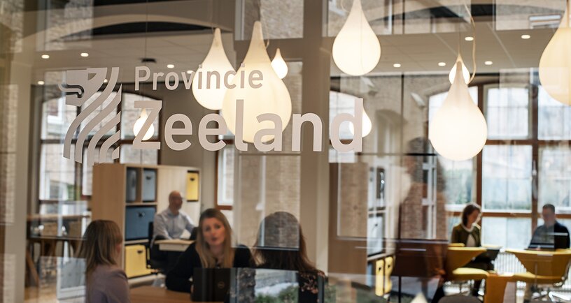 Zicht op de netwerkruimte door glazen wand met daarop het logo van de Provincie Zeeland. Beeld Mechteld Jansen