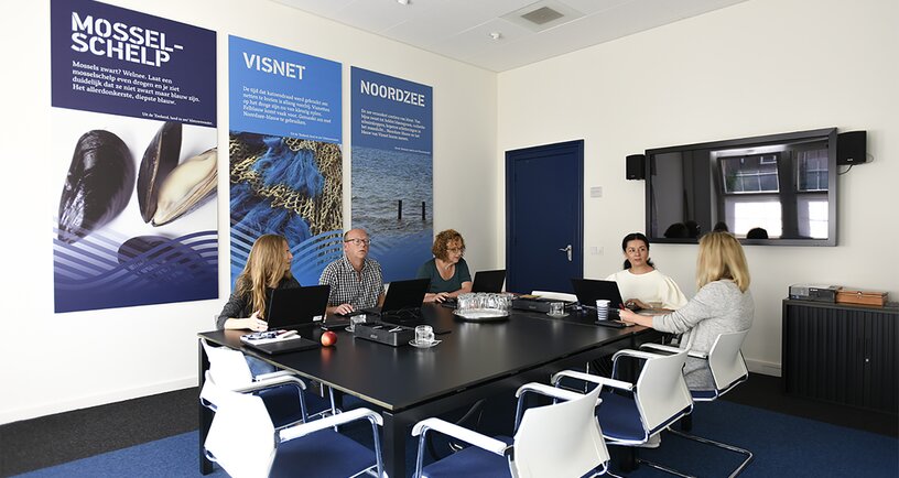 5 collega's in overleg in vergaderzaal van het abdijcomplex