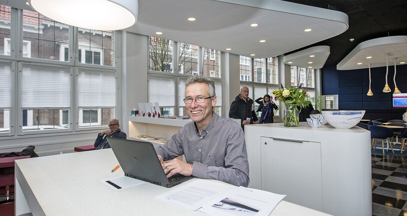 Collega achter de laptop in de ontmoetingsruimte