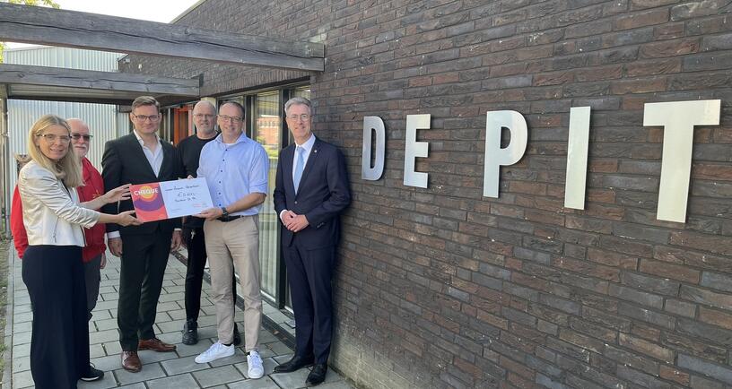 Gedeputeerde Van der Maas overhandigt met betrokkenen van de Vereniging van Zeeuwse Gemeenten en het Oranje Fonds de honderdste toekenning door het Zeeuws Heldenfonds aan Buurthuis de Pit