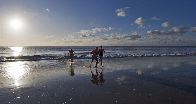 Kinderen op het strand aan het water