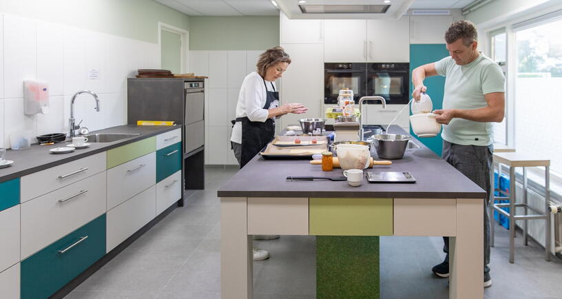 In de gemeenschappelijke keuken bezig