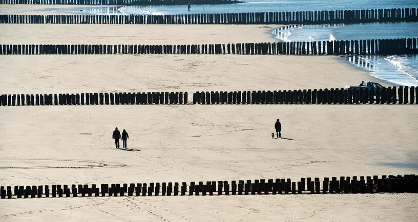 Mensen wandelen over het strand van Westkapelle.