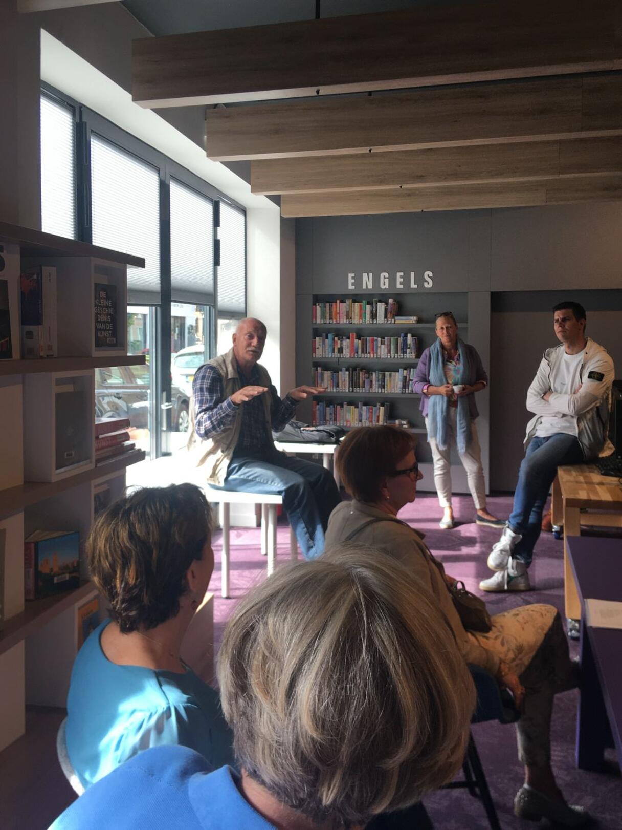 mensen zitten in winkel met boeken