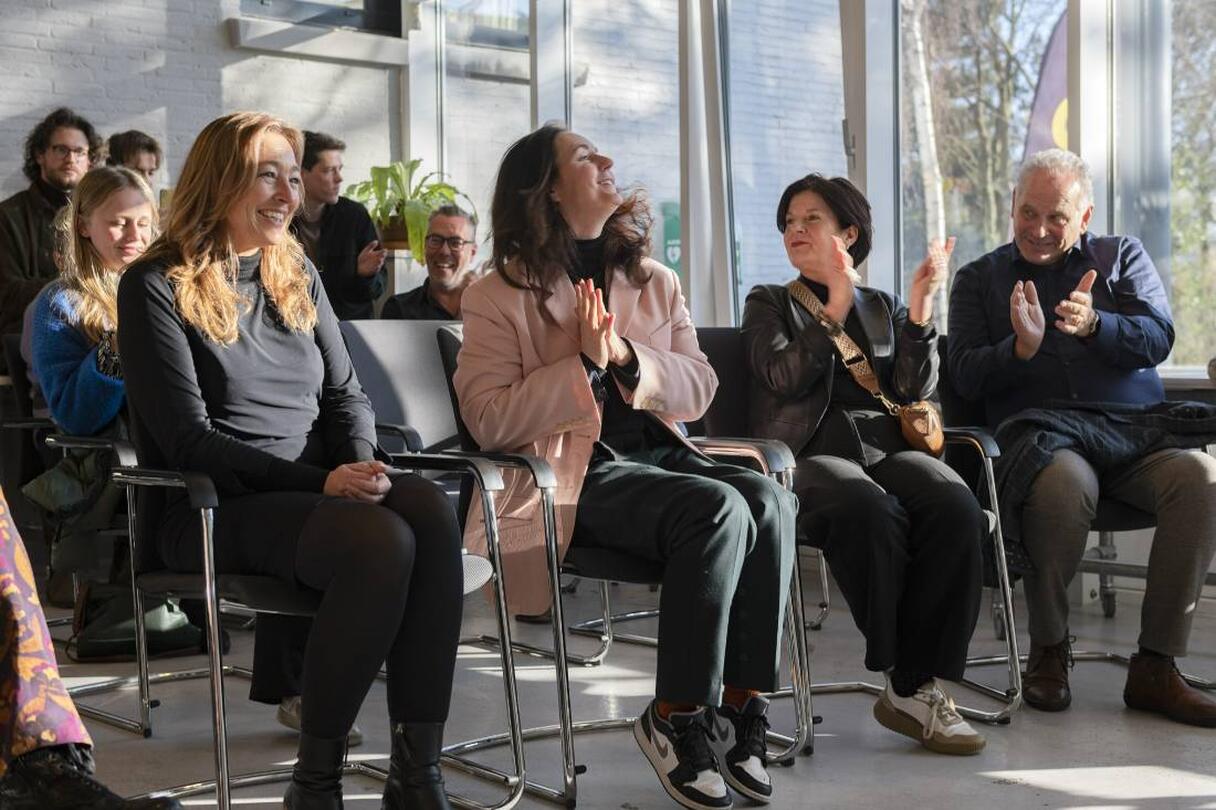 publiek zit op stoelen en klappen