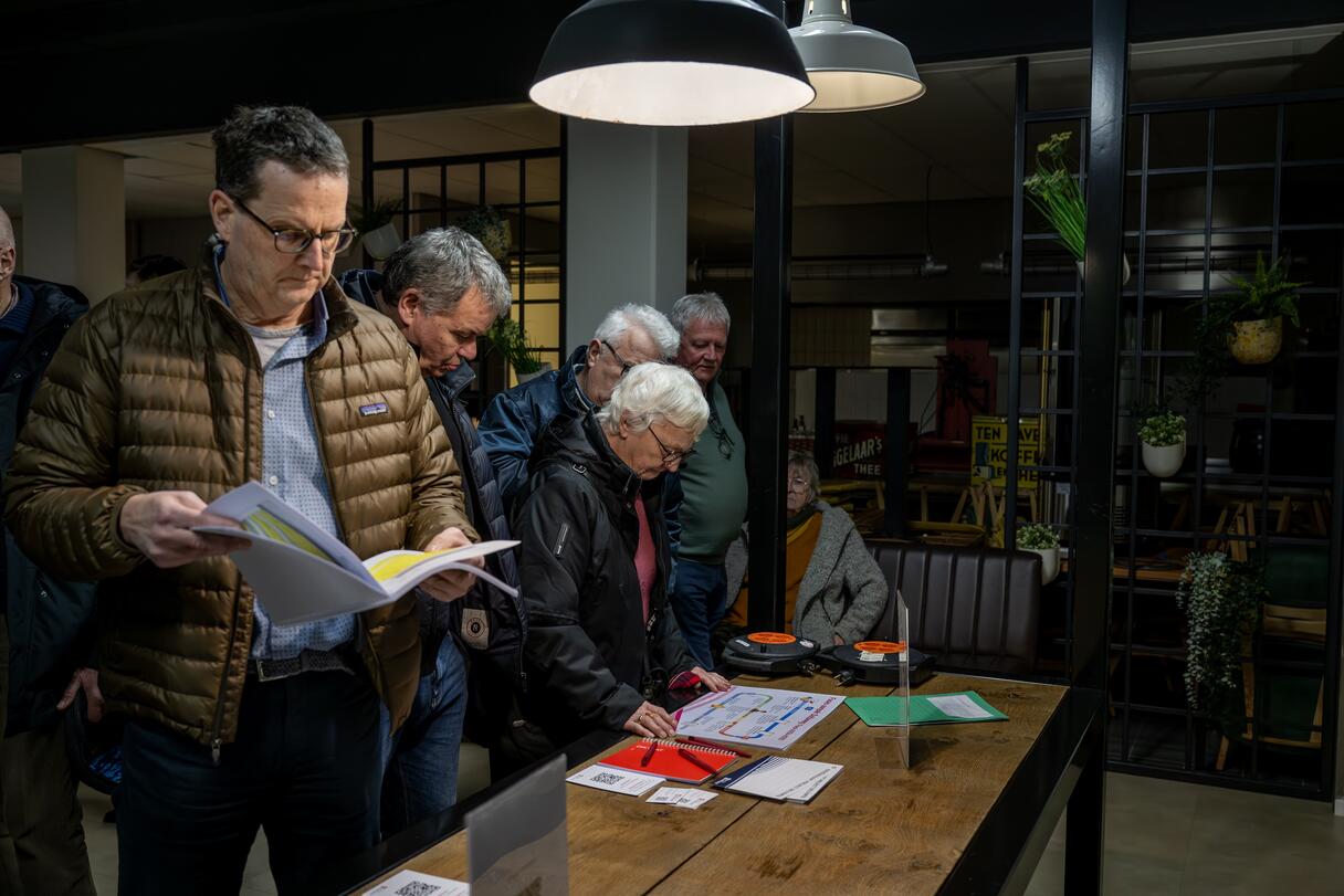 Bezoekers bekijken documenten tijdens de inloopavond over de Deltaweg in Goes