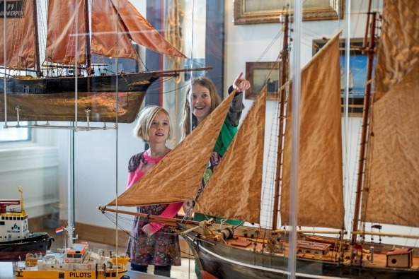 Twee kinderen bekijken een model van een oud zeilschip