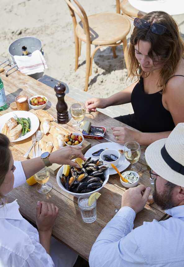 Genieten van mosselpannetje aan tafel op het strand. Beeld: Nederlands Mosselbureau