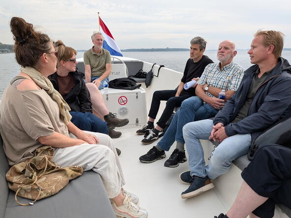 Gastheren en gastvrouwen van het Veerse Meer in een boot op het water bij Kamperland.
